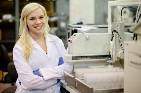 Photo of female co-op student posing in a lab coat